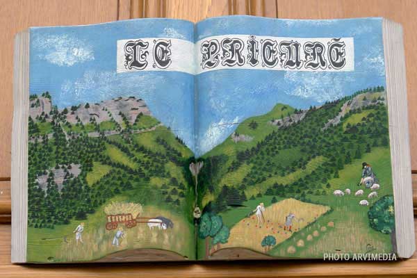 décoration du prieuré d'Entremont sculpture murale représentant un livre avec des laboureurs et des paysans au travail